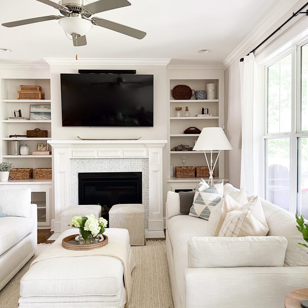 clean living room with fireplace, tv and two white couches designed by The Highpoint House