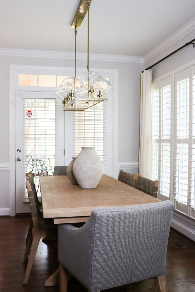 modern dining room with gray chair and gold light feature