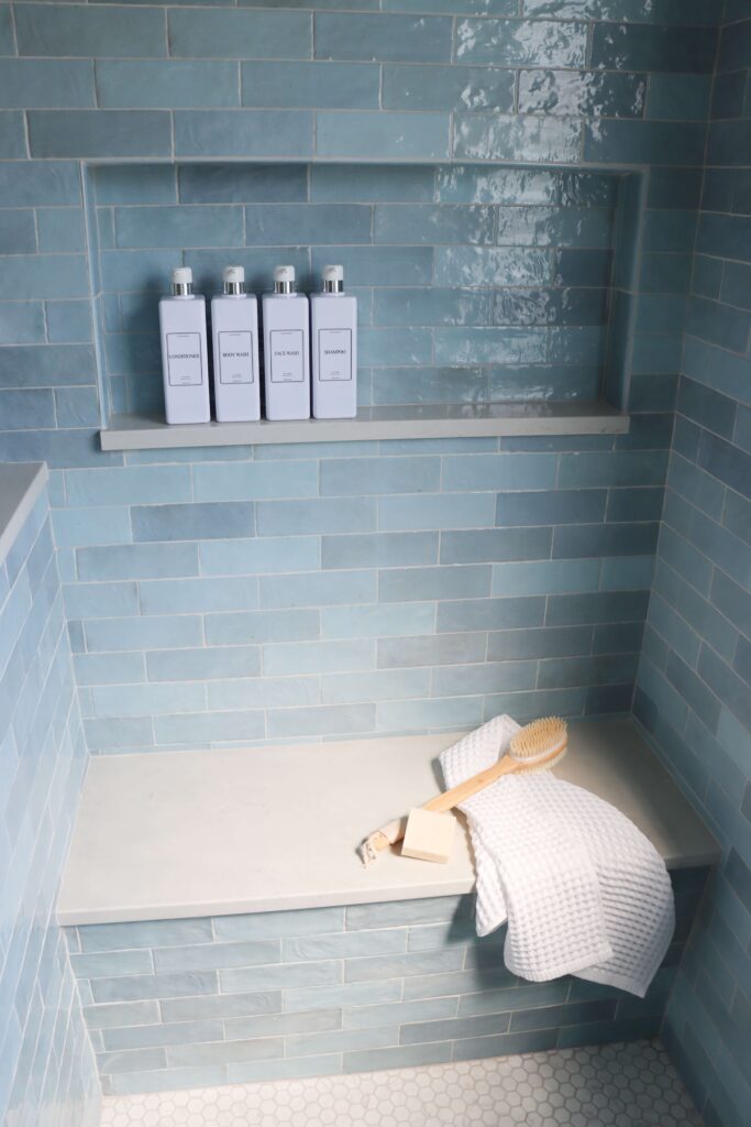 a shower bench with a towel and a brush
